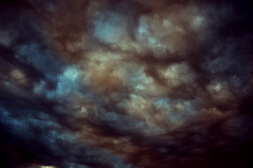 Storm clouds at sunset on the moody sky.