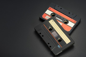Black audio tape compact cassettes on black background