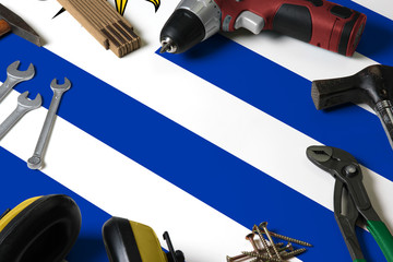 Uruguay flag on repair tool concept wooden table background. Mechanical service theme with national objects.