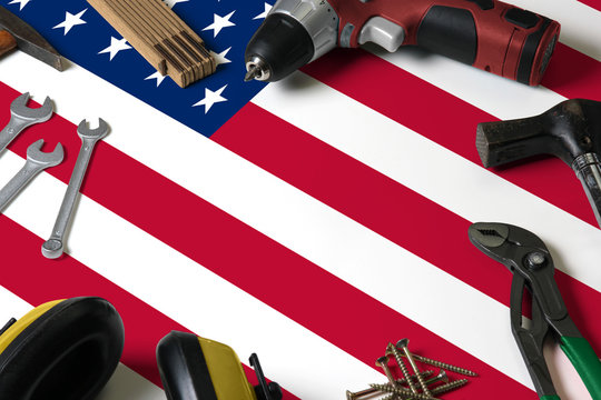 United States flag on repair tool concept wooden table background. Mechanical service theme with national objects.