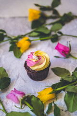 Pink and yellow cupcakes with fuchsia and yellow rose flowers