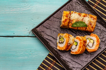 Grilled tiger prawn sushi. Japanese or Korean roll with different fresh ingredients. Trendy turquoise background