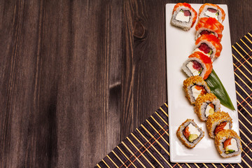 Assorted sushi set. Japanese or Korean roll with different fresh ingredients. Trendy black background