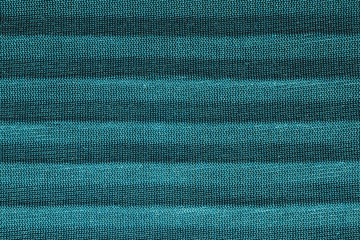 Green textile with parallel folds. fabric texture with flat creases. cloth background