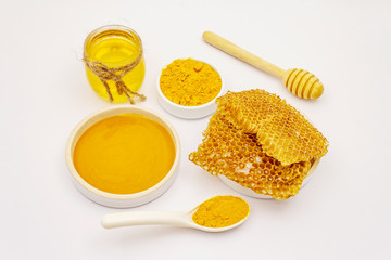 Dry turmeric powder, honey and honeycombs isolated on white background