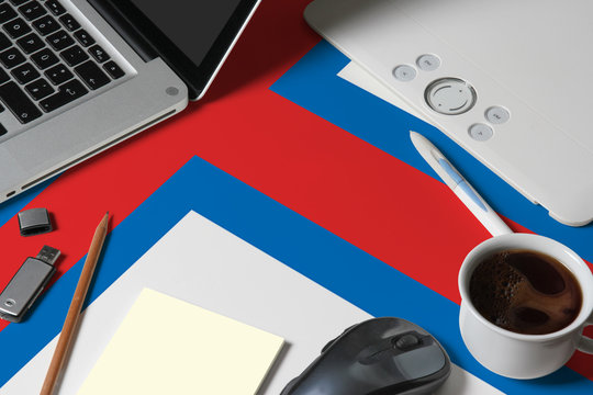 Faroe Islands national flag on top view work space of creative designer with laptop, computer keyboard, usb drive, graphic tablet, coffee cup, mouse on wooden table.