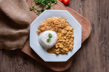 Obraz na płótnie Canvas Food plate with meat stroganoff with rice and french fries. Wood background. Flat lay.