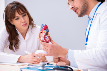 Young male doctor cardiologist and female student in the classro