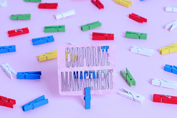Handwriting text Corporate Management. Conceptual photo all Levels of Managerial Personnel and Excutives Colored clothespin papers empty reminder pink floor background office pin