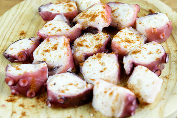 Slices of octopus topped with red  spicy pepper by special recipe. Traditional mediterranean dish of Galicia.