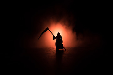 Death with a scythe in the dark misty forest. Woman horror ghost holding reaper in forest,...