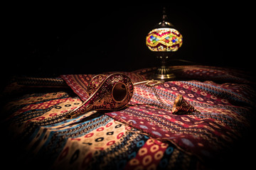 Lamp of wishes concept. Antique Aladdin arabian nights genie style oil lamp with soft light white...