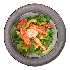 Crab meat with corn salad and citrus wedges in plate, isolated, shot from above