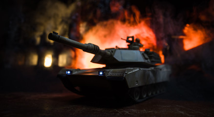 War Concept. Armored vehicle silhouette fighting scene on war foggy sky background at night.