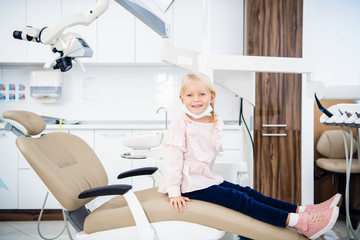 A little girl sitting in the dentistry office