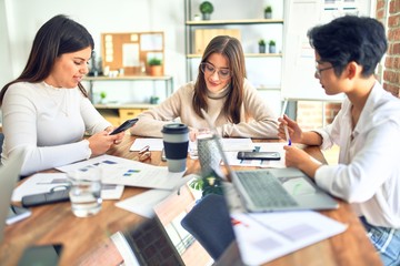 Fototapeta premium Beautiful businesswomen smiling happy. Sitting with smile on face working using smartphone and laptop at the office