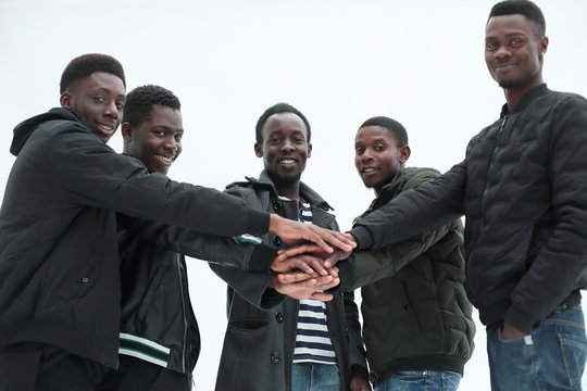 close up. group of guys putting their hands together.