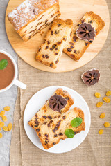 Homemade cake with raisins, dried persimmon and a cup of hot chocolate on a gray concrete background. top view.