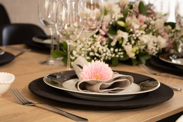Elegant table setting with flowers and white and black dinnerware