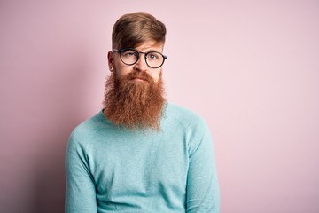 Handsome Irish redhead man with beard wearing glasses over pink isolated background looking sleepy and tired, exhausted for fatigue and hangover, lazy eyes in the morning.