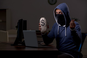 Male hacker hacking security firewall late in office