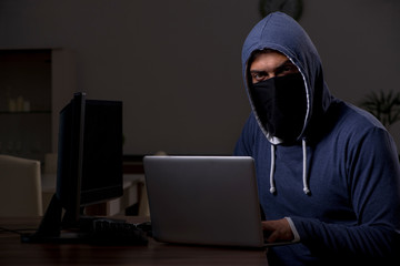 Male hacker hacking security firewall late in office