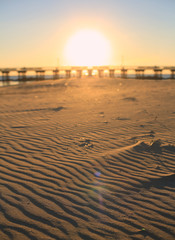 Sunset on the beach behind the bridge