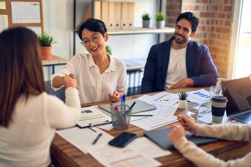 Group of business workers smiling happy and confident. Working together with smile on face shaking hands at the office