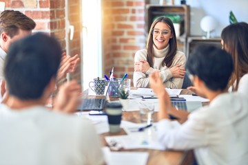 Group of business workers smiling happy and confident. Working together with smile on face applauding one of them at the office