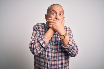 Obraz premium Senior handsome man wearing casual shirt standing over isolated white background shocked covering mouth with hands for mistake. Secret concept.