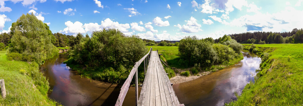 Old wooden bridge over a small river © Galina Atroshchenko