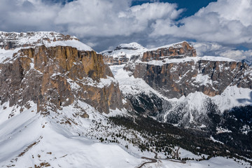 Aerial view of twisting road in a mountains of Italy, Dolomites, is serpentine among the snow-covered hills, is famous place among skiers and fans to understand a known by sports cars, mountains peak