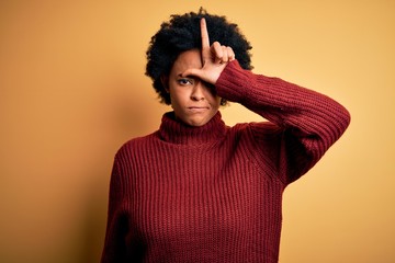 Young beautiful African American afro woman with curly hair wearing casual turtleneck sweater...