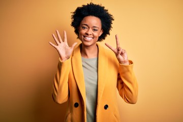 Obraz na płótnie Canvas Young beautiful African American afro businesswoman with curly hair wearing yellow jacket showing and pointing up with fingers number seven while smiling confident and happy.