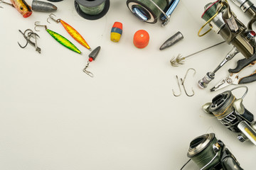 Fishing rods and reels fishing tackle on white leather background.