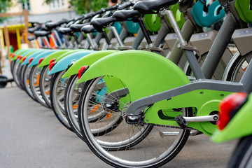 bike rental, green with baskets and red and white lights and orange reflectors. Bicycle parking.