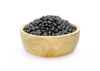 Fototapeta na wymiar Black turtle bean (Black bean) in wooden bowl isolated on white background. In Traditional Chinese Medicine black beans are known for their ability to tonify blood and yin, also regulate water.
