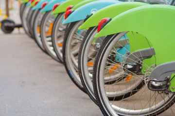 bike rental, green with baskets and red and white lights and orange reflectors. Bicycle parking.
