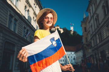 Woman tourist with slovenian flag in Ljubljana, Slovenia, Europe.