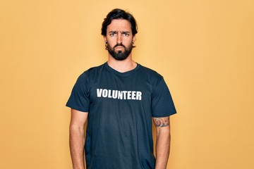 Young handsome hispanic volunteer man wearing volunteering t-shirt as social care depressed and worry for distress, crying angry and afraid. Sad expression.