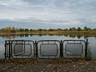 Autumn landscape river and iron fence in Pripyat, Chernobyl Exclusion Zone in Ukraine