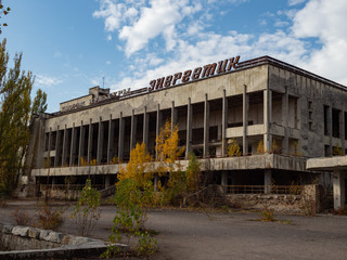 Fototapeta na wymiar House of culture Energetic in abandoned ghost town Pripyat, post apocalyptic city, autumn season in Chernobyl exclusion zone, Ukraine. Inscription in russian: 
