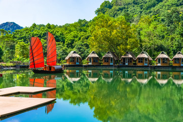 Junk. Beautiful traditional vietnamese boat with red sails on a picturesque lake in the jungle....