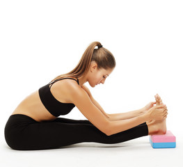 Fototapeta na wymiar young woman practicing yoga using yoga blocks