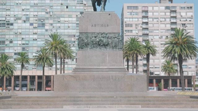 Camera tilt up from ground to reveal the front of Artigas statue in the center of Plaza Independencia square Montevideo, Uruguay