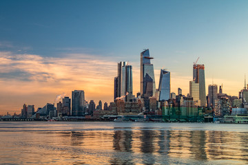 Fototapeta na wymiar Cityscape of a sunrise over Manhattan's west side from across the Hudson River