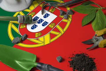 Portugal flag with gardening tools background on table. Spring in the garden concept with free copy space.