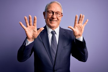 Grey haired senior business man wearing glasses and elegant suit and tie over purple background showing and pointing up with fingers number ten while smiling confident and happy.