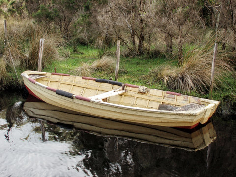 Old timber dinghy tied up at a small inlet in Strahan Harbour