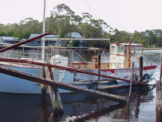 Old timber fishing boat moored at a rundown jetty